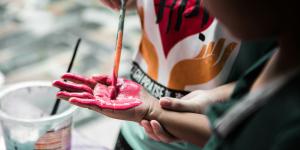 child painting their hand