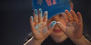 child with paint on their hands